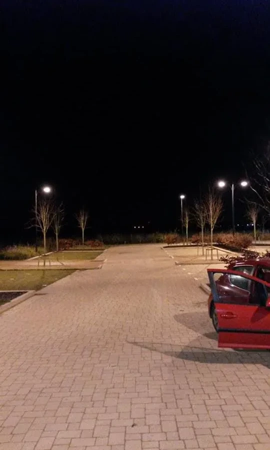 Car park lighting columns lit across the parking bays
