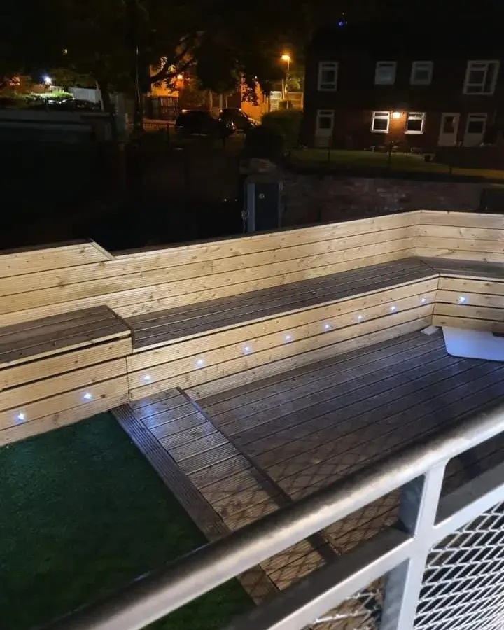 Recessed deck lights along a garden seating area