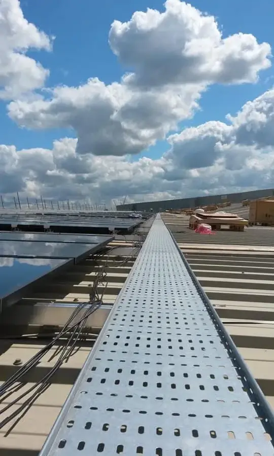 Cable tray run across a commercial roof beside a solar array