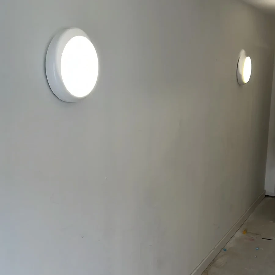 Circular LED bulkhead lights in a commercial corridor