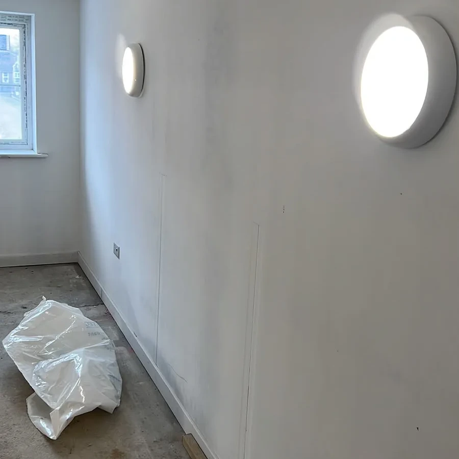 Bulkhead lighting along a corridor being finished