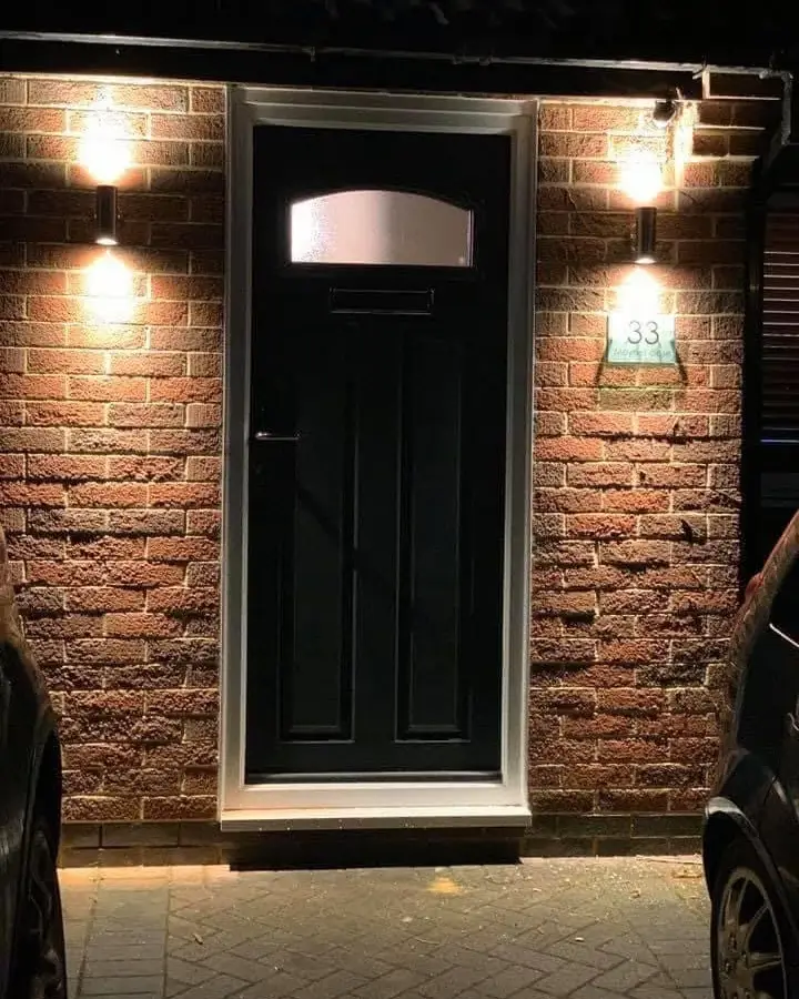 Outdoor wall lights either side of a front door, with an illuminated house number